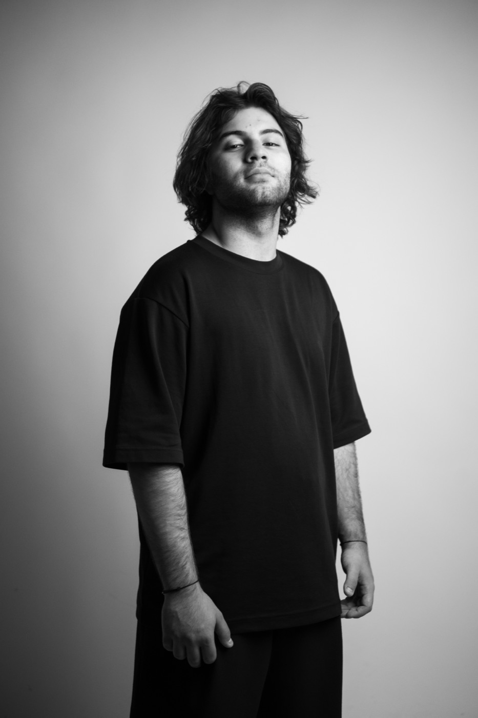 Black and white studio portrait of A DEEN in a black t-shirt